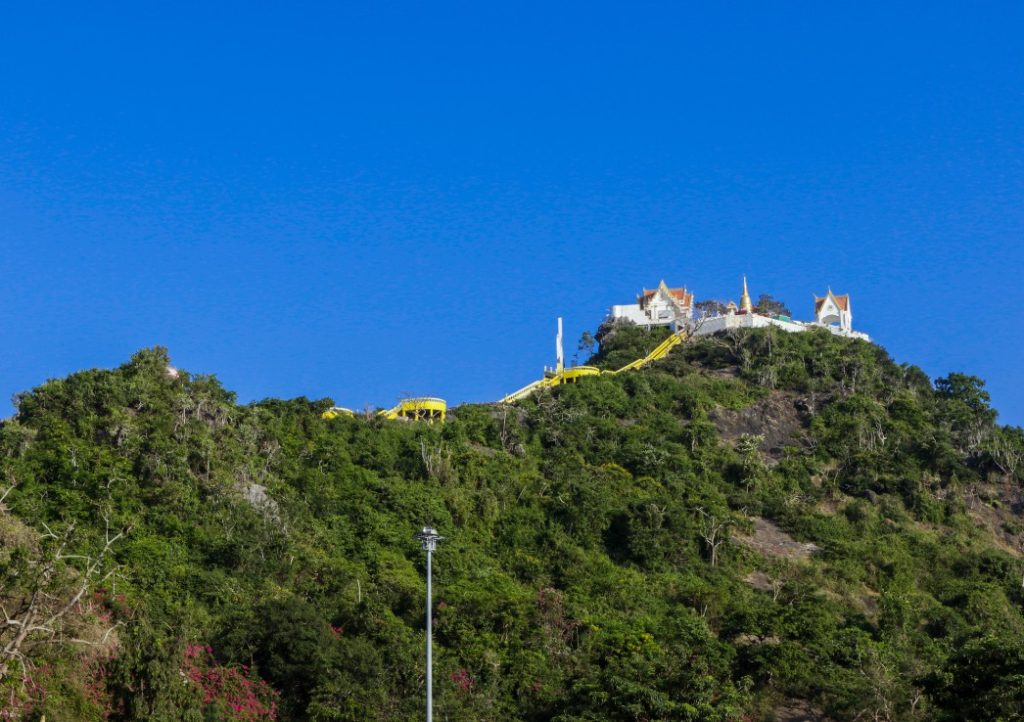 Things to do in Prachuap Khiri Khan. A temple on top of a mountain covered in jungle.