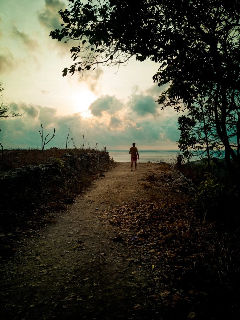 James walking along the path to the cliff's edge on top of Atuh beach for sunrise