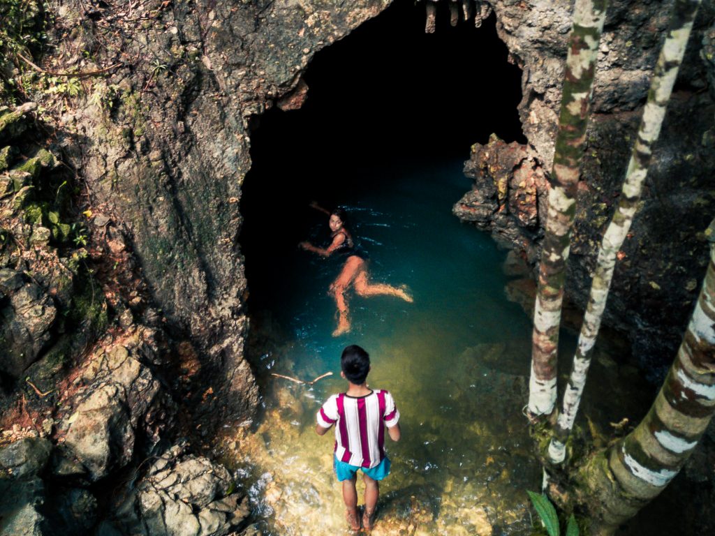 Jacqueline swimming into a cave at Tayangban Cave & Pool