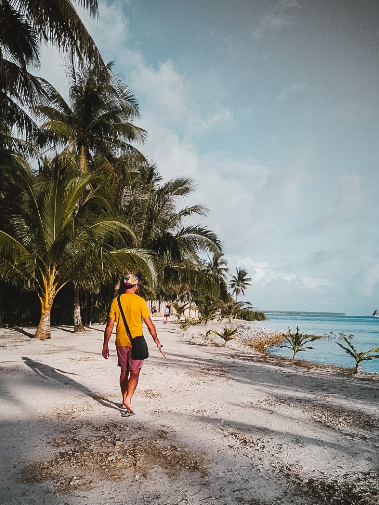 Walking along a palm fringed white sand path at Doot beach Siargao