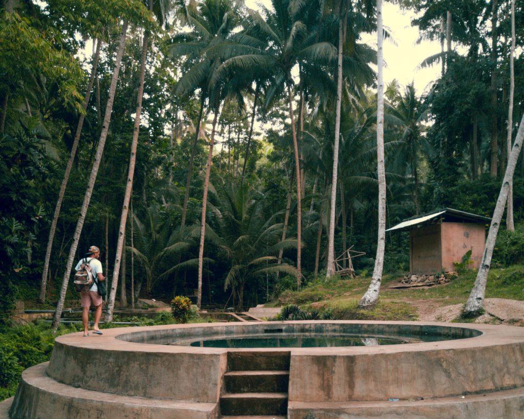 Surrounded in huge coconut trees and a tropical landscape the man made water system and a big concrete pool contrast with their natural surrounding at Lugnason Falls