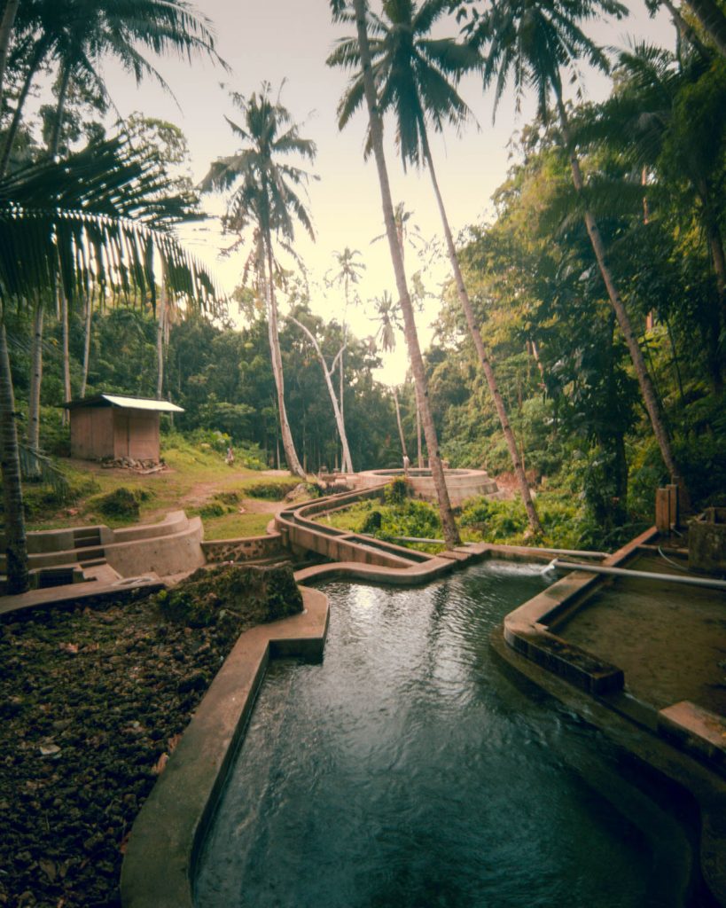 Surrounded in huge coconut trees and a tropical landscape the man made water system and a big concrete pool contrast with their natural surrounding at Lugnason Falls
