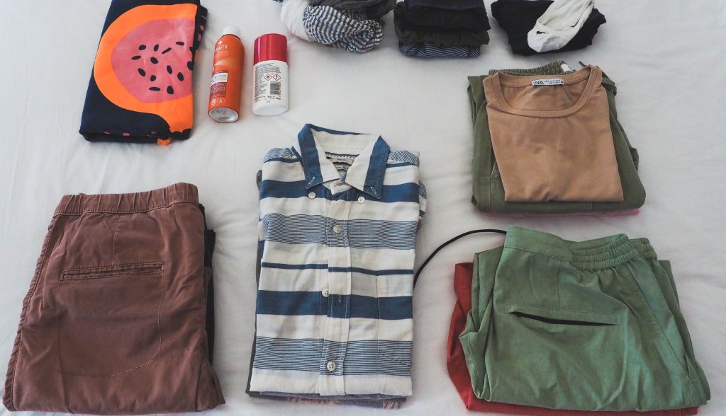 Our packing outfits laying on the bed before going into the handy backpack