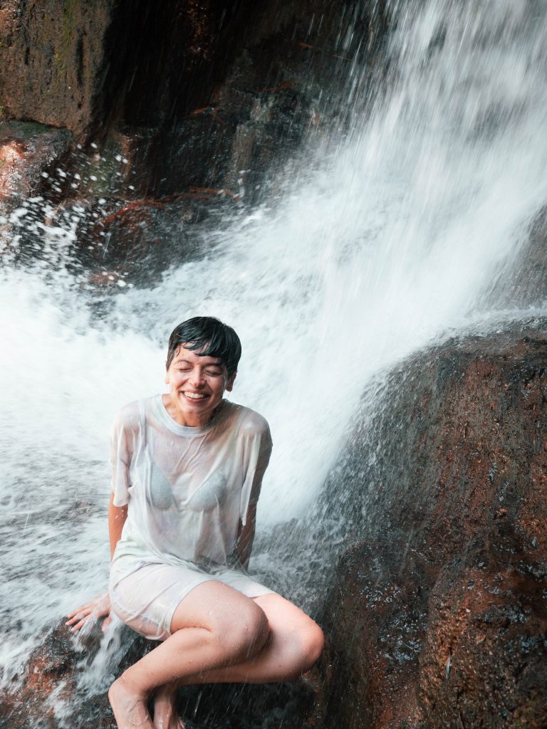 Jacqueline under the cascade and getting completely soaked