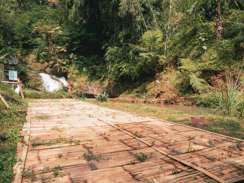 A huge a bamboo mat next to the river and a small cascade where guests can camp