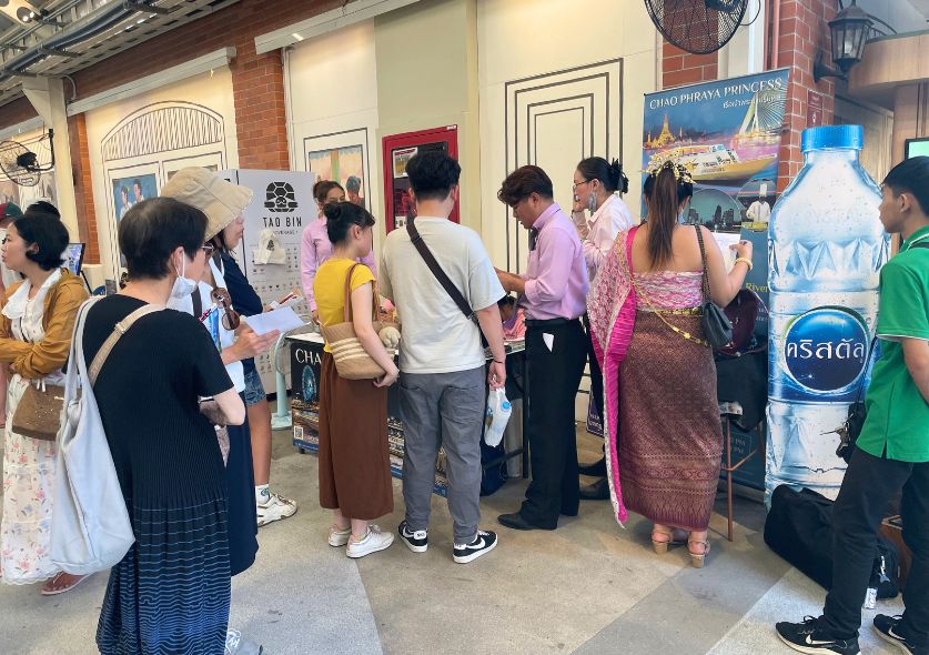 People waiting in line to buy the tickets for a river cruise in Bangkok