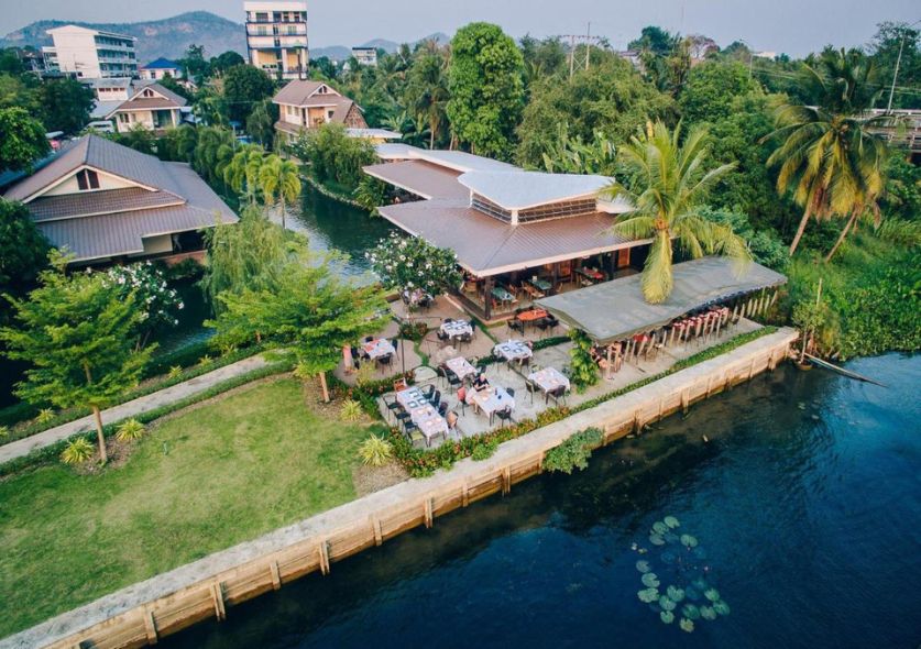 A beautiful resort perched on a river and surrounded by tropical trees