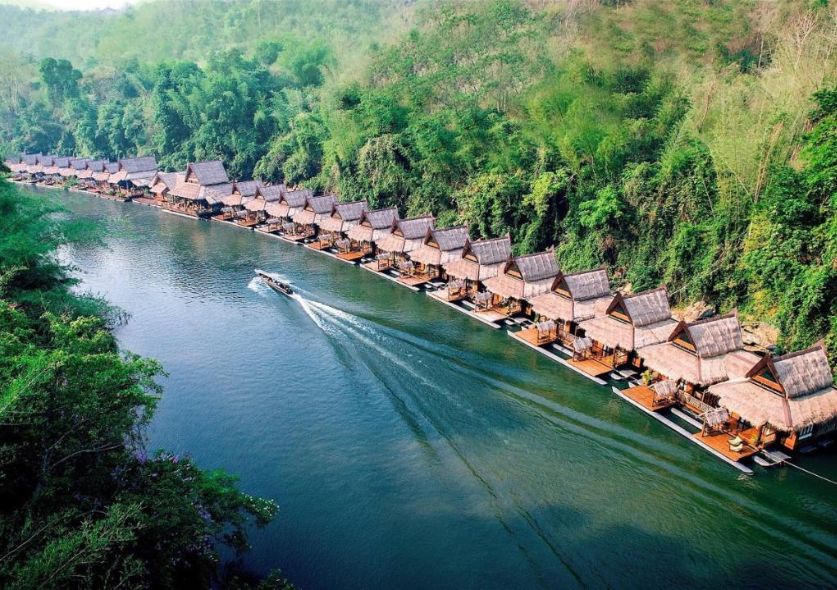 Floating resorts lined along a river in Kanchanaburi and surrounded by jungle