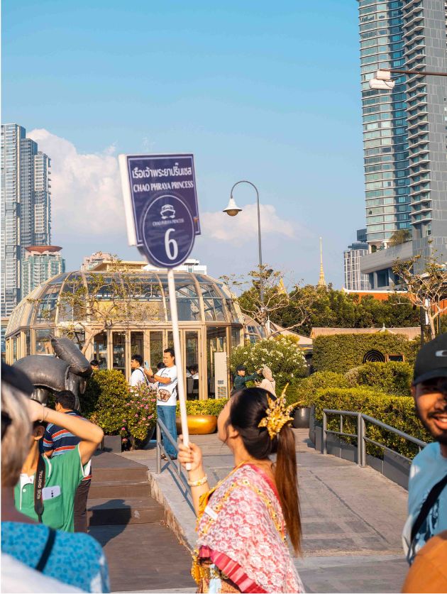 Chao Phraya river sunset cruise. A woman holding a sign for tourists to follow