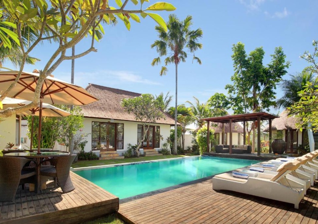 Bungalows surrounding a pool with tropical trees
