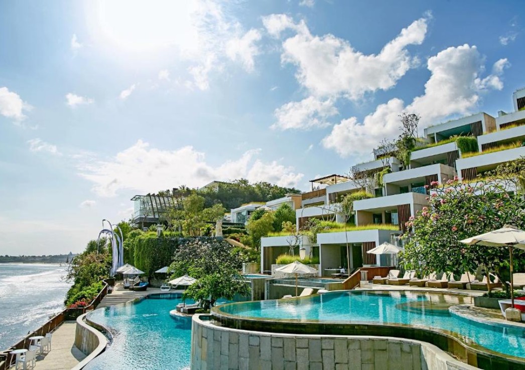 A resort with suites overlooking a pool